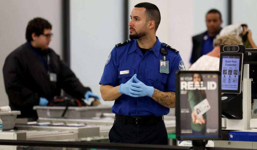 MIAMI, FLORIDA - DECEMBER 20: A TSA agent works in a TSA Pre checkpoint at the Miami International Airport as some of the year's busiest travel days occur during the holiday season on December 20, 2024 in Miami, Florida. As the U.S. government works to pass a new funding resolution, some travelers fear that if the government shuts down, they will endure longer lines at airports as some security staffers and air traffic controllers would not be getting paid and could choose not to report to work. Transportation Security Administration (TSA) workers are deemed essential, meaning they must stay on the job even if the government shuts down (Photo by Joe Raedle/Getty Images)