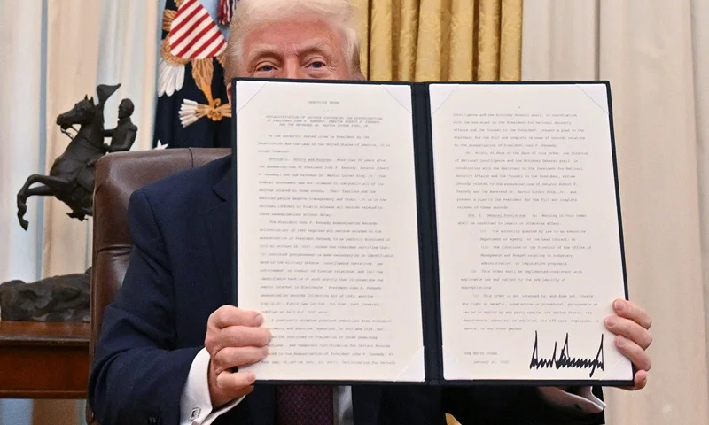 US President Donald Trump holds the executive order he signed to declassify the files of slained former President John F. Kennedy, former Attorney General Robert F. Kennedy and civil rights leader Martin Luther King Jr., in the Oval Office of the White House in Washington, DC, on January 23, 2025. (Photo by ROBERTO SCHMIDT / AFP) (Photo by ROBERTO SCHMIDT/AFP via Getty Images)