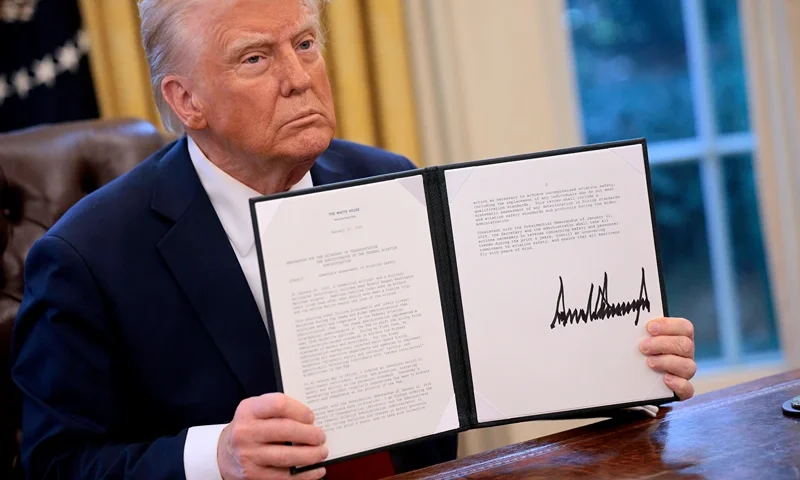 U.S. President Donald Trump hold up a memorandum he signed ordering an immediate assessment of aviation safety and ordering an elevation of what he called “competence” over “D.E.I.” in the Oval Office at the White House on January 30, 2025 in Washington, DC. Trump also signed a executive order to appoint Chris Rocheleau as the deputy administrator of the Federal Aviation Administration. (Photo by Chip Somodevilla/Getty Images)