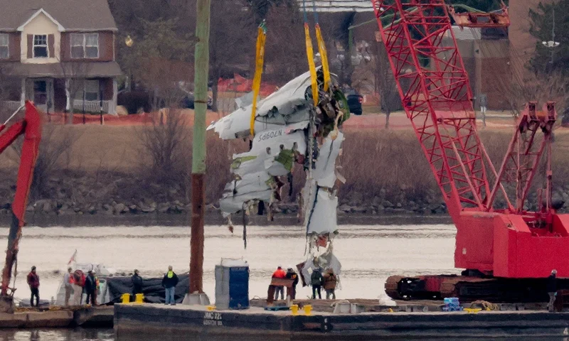 A large portion of the damaged plane fuselage is lifted from the Potomac River during recovery efforts after the American Airlines crash on February 03, 2025 in Arlington, Virginia. An American Airlines flight from Wichita, Kansas collided midair with a military Black Hawk helicopter while on approach to Ronald Reagan Washington National Airport on January 29, 2025 outside of Washington, DC. According to reports, there were no survivors among the 67 people onboard both aircraft. (Photo by Chip Somodevilla/Getty Images)