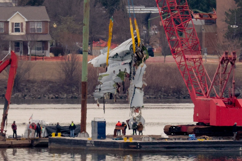 A large portion of the damaged plane fuselage is lifted from the Potomac River during recovery efforts after the American Airlines crash on February 03, 2025 in Arlington, Virginia. An American Airlines flight from Wichita, Kansas collided midair with a military Black Hawk helicopter while on approach to Ronald Reagan Washington National Airport on January 29, 2025 outside of Washington, DC. According to reports, there were no survivors among the 67 people onboard both aircraft. (Photo by Chip Somodevilla/Getty Images)