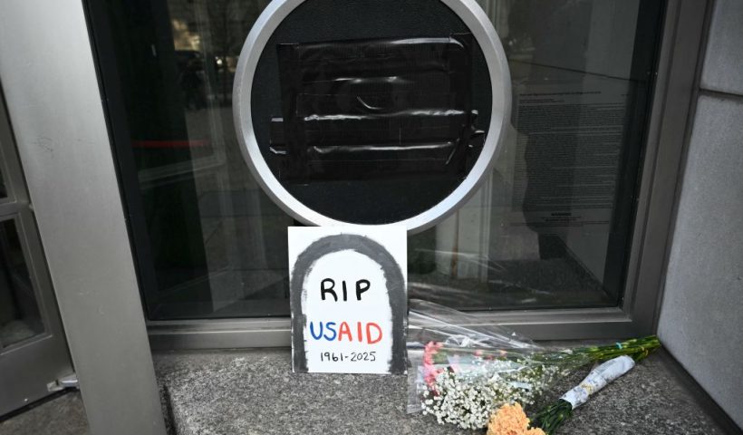 Tributes are placed beneath the covered seal of the US Agency for International Development (USAID) at their headquarters in Washington, DC, on February 7, 2025. US President Donald Trump on February 7, 2025 called for USAID to be shuttered, escalating his unprecedented campaign to dismantle the humanitarian agency. (Photo by Mandel NGAN / AFP) (Photo by MANDEL NGAN/AFP via Getty Images)
