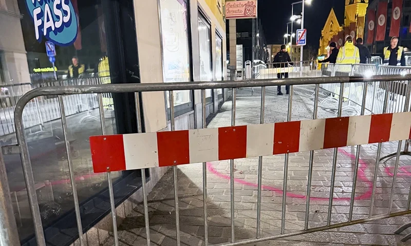 Candles are lit near a police barrier after a knife attack near the main square in the city centre of Villach, southern Austria on February 15, 2025. A 14-year-old boy died and four other people were injured in the knife attack in southern Austria on February 15, police said, adding they have arrested a 23-year-old Syrian asylum seeker. (Photo by GERD EGGENBERGER / APA / AFP) / Austria OUT (Photo by GERD EGGENBERGER/APA/AFP via Getty Images)