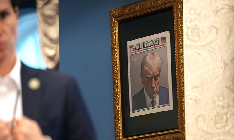WASHINGTON, DC - FEBRUARY 14: A copy of U.S. President Donald Trump's mugshot on the front of the New York Post is framed in an office just outside the Oval Office at the White House on February 14, 2025 in Washington, DC. President Trump signed a series of executive order including announcing his administration will withhold federal funding from schools and universities that impose COVID-19 vaccine mandate. (Photo by Andrew Harnik/Getty Images)