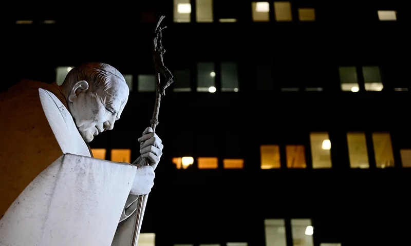 A picture taken at night shows the statue of John Paul II at the Gemelli University Hospital where Pope Francis is hospitalized with pneumonia, in Rome on February 28, 2025. (Photo by Tiziana FABI / AFP) (Photo by TIZIANA FABI/AFP via Getty Images)