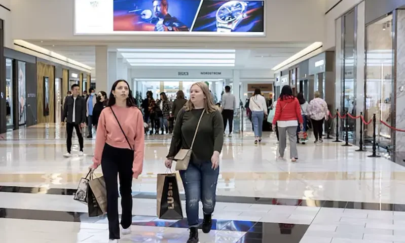 People carrying shopping bags walk inside the King of Prussia shopping mall in King of Prussia, Pennsylvania, U.S. November 26, 2021. REUTERS/Rachel Wisniewski/File Photo