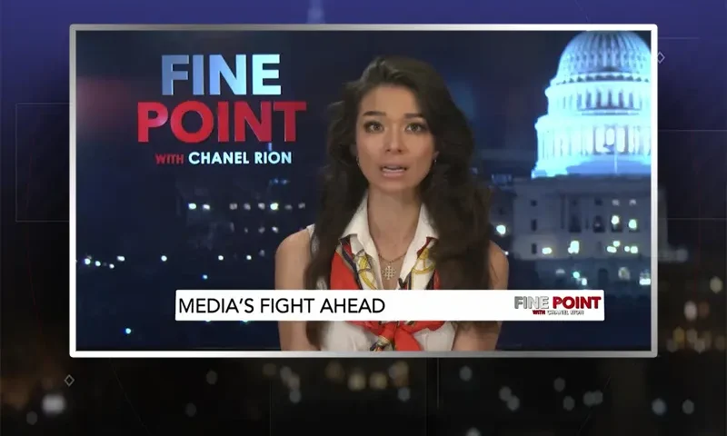 Video still of the host of Fine Point at the desk of their talk show on One America News Network.
