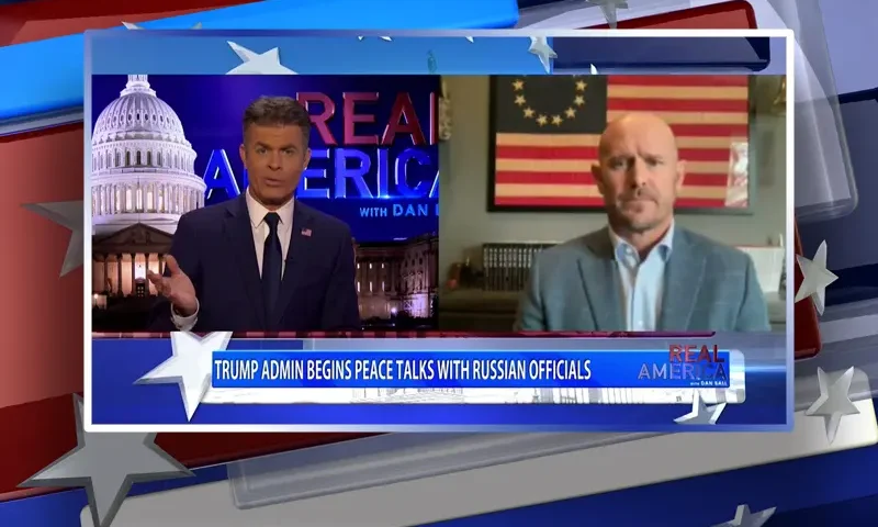 Video still from Real America on One America News Network showing a split screen of the host on the left side, and on the right side is the guest, Mike Sarraille.