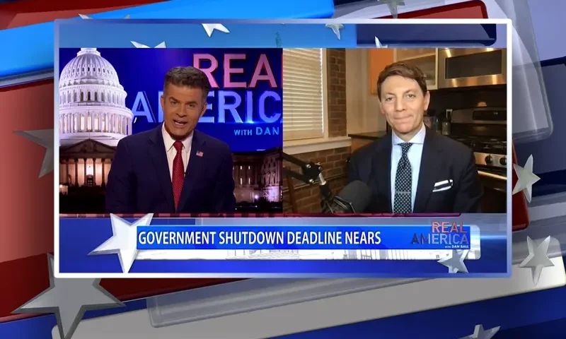 Video still from Real America on One America News Network showing a split screen of the host on the left side, and on the right side is the guest, Hogan Gidley.