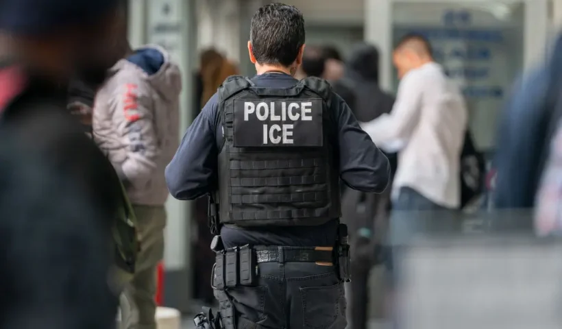 NEW YORK, NEW YORK - JUNE 6: An ICE agent monitors hundreds of asylum seekers being processed upon entering the Jacob K. Javits Federal Building on June 6, 2023 in New York City. New York City has provided sanctuary to over 46,000 asylum seekers since 2013, when the city passed a law prohibiting city agencies from cooperating with federal immigration enforcement agencies unless there is a warrant for the person's arrest.(Photo by David Dee Delgado/Getty Images)