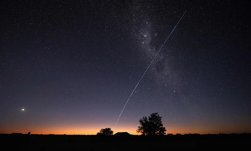 TOPSHOT - This long-exposure image shows a trail of a group of SpaceX's Starlink G6-27 satellites passing over Uruguay, with part of the Milky Way and planet Venus (L) in the frame, as seen from the countryside some 185 km north of Montevideo near Capilla del Sauce, Florida Department, at twilight early on November 12, 2023. (Photo by Mariana SUAREZ / AFP) (Photo by MARIANA SUAREZ/AFP via Getty Images)