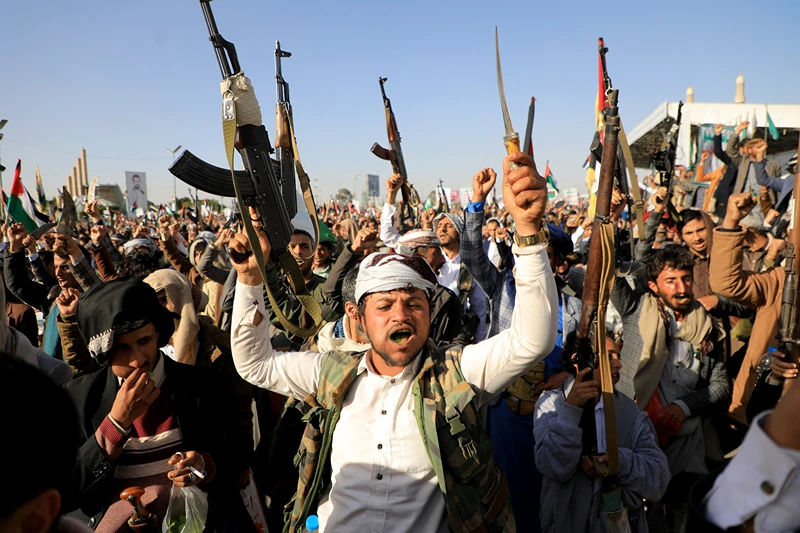 TOPSHOT - Huthi fighters brandish their weapons during a protest following US and British forces strikes, in the Huthi-controlled capital Sanaa on January 12, 2024 amid the ongoing battles between Israel and the militant Hamas group in Gaza. US and British forces struck rebel-held Yemen early on January 12, after weeks of disruptive attacks on Red Sea shipping by the Iran-backed Huthis who say they act in solidarity with Gaza. The pre-dawn air strikes add to escalating fears of wider conflict in the region, where violence involving Tehran-aligned groups in Yemen as well as Lebanon, Iraq and Syria has surged since the Israel-Hamas was began in early October. (Photo by MOHAMMED HUWAIS / AFP) (Photo by MOHAMMED HUWAIS/AFP via Getty Images)