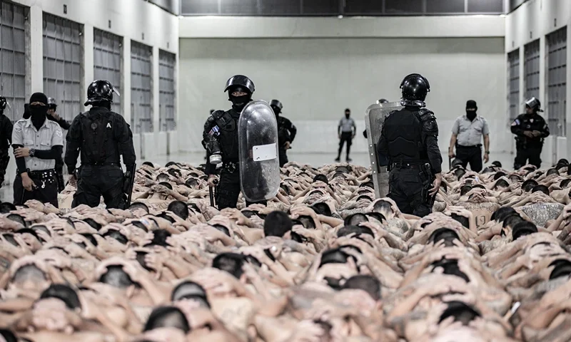 TECOLUCA, EL SALVADOR - JUNE 11: In this handout picture provided by the Salvadoran presidency Police officers guard inmates as 2,000 detainees are moved to mega- prison Terrorist Confinement Centre (CECOT) on June 11, 2024 in Tecoluca, El Salvador. Since president Bukele announced a state of exception in March 2022, over 80,000 suspected gang members have been arrested. Human Rights organizations denounce abuses and due process violations. El Salvador has one of highest crime rates in Latin America. (Photo by Handout/Presidencia El Salvador via Getty Images )