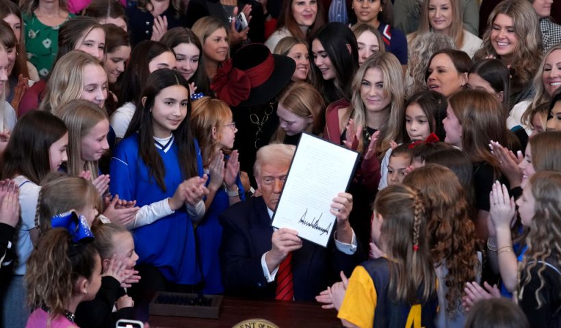 WASHINGTON, DC - FEBRUARY 05: U.S. President Donald Trump joined by women athletes signs the “No Men in Women’s Sports” executive order in the East Room at the White House on February 5, 2025 in Washington, DC. The executive order, which Trump signed on National Girls and Women in Sports Day, prohibits transgender women from competing in women’s sports and is the third order he has signed that targets transgender people. (Photo by Andrew Harnik/Getty Images)