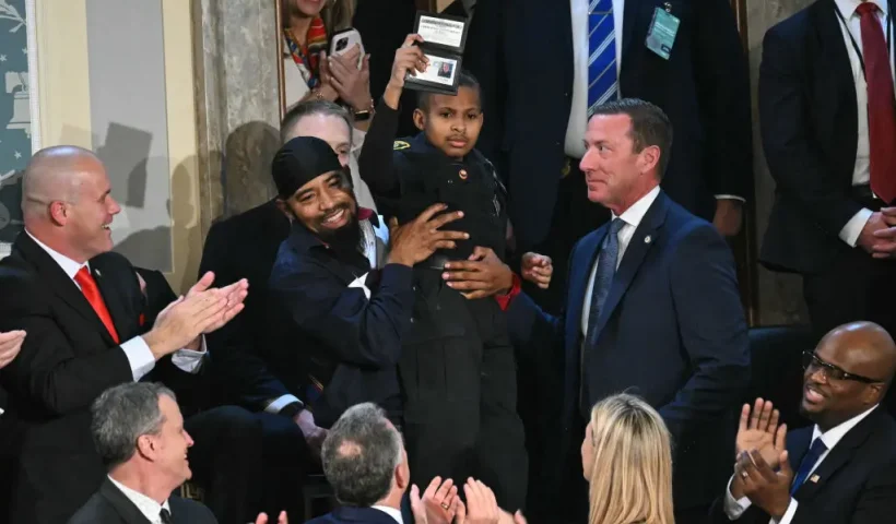 3-year-old cancer survivor Devarjaye "DJ" Daniel is lifted up by his father Theodis Daniel after given credentials from US Secret Service Director Sean Curran after US President Donald Trump made him an honorary member of the US Secret Service during his address to a joint session of Congress at the US Capitol in Washington, DC, on March 4, 2025. (Photo by SAUL LOEB / AFP) (Photo by SAUL LOEB/AFP via Getty Images)