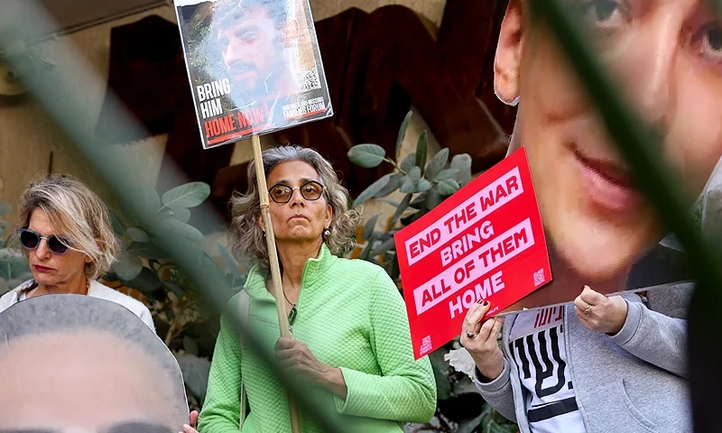 Demonstrators raise cutout portraits of Israeli hostages during a protest calling for the implementation of the second phase and the completion of the agreement for the release of all hostages held captive in Gaza since the October 7, 2023 attack by Palestinian militants, in Tel Aviv on March 6, 2025. (Photo by JACK GUEZ/AFP via Getty Images)
