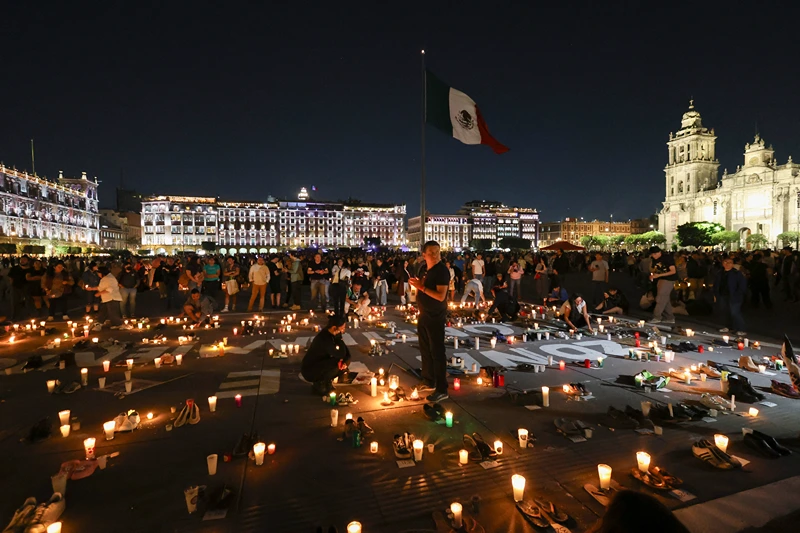TOPSHOT - People light candles during the vigil 'Luto Nacional Tehuchitlan' for those who lost their lives in the 'Izaguirre Ranch', at the Zócalo square in Mexico City on March 15, 2025. A grisly discovery of charred bones, shoes and clothing at 'Izaguirre Ranch' a suspected drug cartel training ground has prompted demands for answers and justice from relatives of the more than 100,000 people missing in Mexico. (Photo by Silvana FLORES / AFP) (Photo by SILVANA FLORES/AFP via Getty Images)