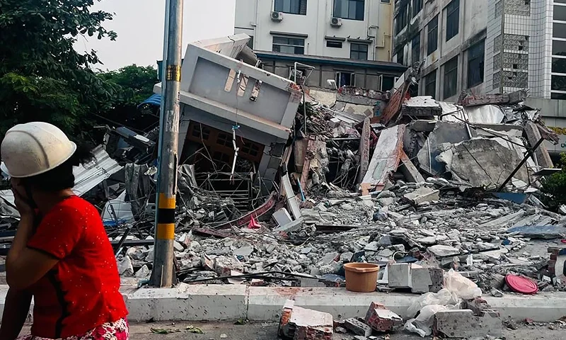 A resident looks on next to a collapsed building in Mandalay on March 28, 2025, after an earthquake in central Myanmar. A powerful earthquake rocked central Myanmar on March 28, buckling roads in capital Naypyidaw, damaging buildings and forcing people to flee into the streets in neighbouring Thailand. (Photo by AFP) (Photo by STR/AFP via Getty Images)