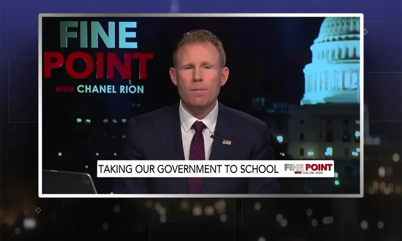 Video still of the host of Fine Point at the desk of their talk show on One America News Network.
