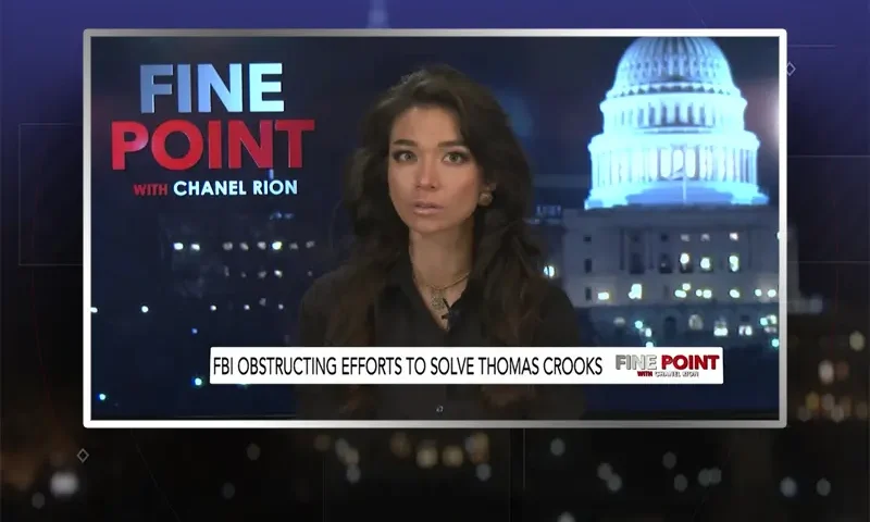 Video still of the host of Fine Point at the desk of their talk show on One America News Network.