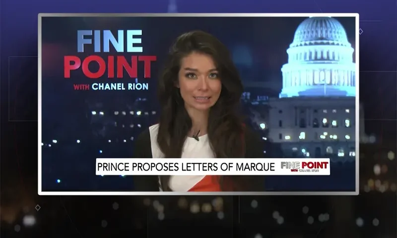 Video still of the host of Fine Point at the desk of their talk show on One America News Network.