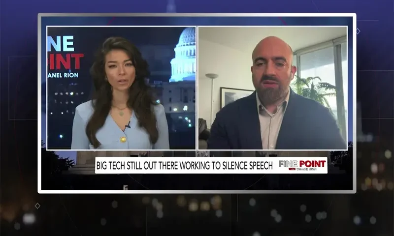 Video still from Fine Point on One America News Network showing a split screen of the host on the left side, and on the right side is the guest, Mike Benz.
