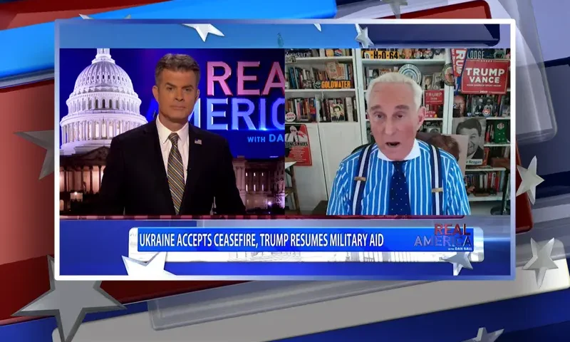 Video still from Real America on One America News Network showing a split screen of the host on the left side, and on the right side is the guest, Roger Stone.