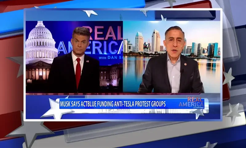 Video still from Real America on One America News Network showing a split screen of the host on the left side, and on the right side is the guest, Darrell Issa.