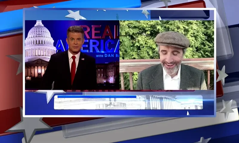 Video still from Real America on One America News Network showing a split screen of the host on the left side, and on the right side is the guest, Marc Morano.
