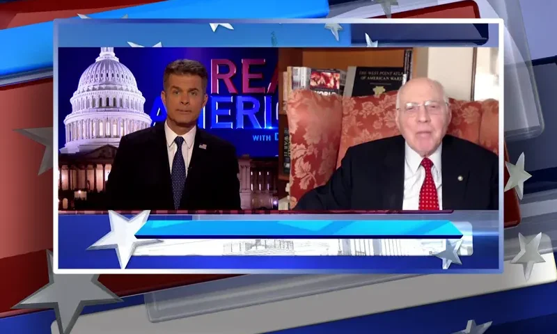 Video still from Real America on One America News Network showing a split screen of the host on the left side, and on the right side is the guest, Lt. Col. Robert Maginnis.
