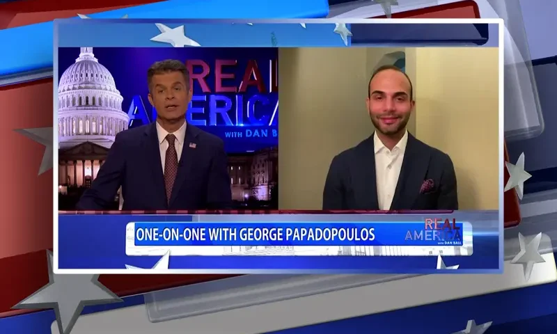 Video still from Real America on One America News Network showing a split screen of the host on the left side, and on the right side is the guest, George Papadopoulos.