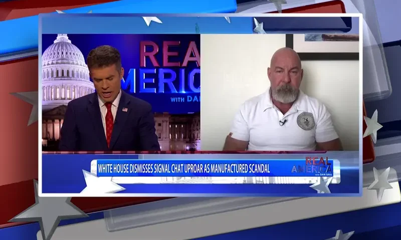 Video still from Real America on One America News Network showing a split screen of the host on the left side, and on the right side is the guest, Jonathan Gilliam.