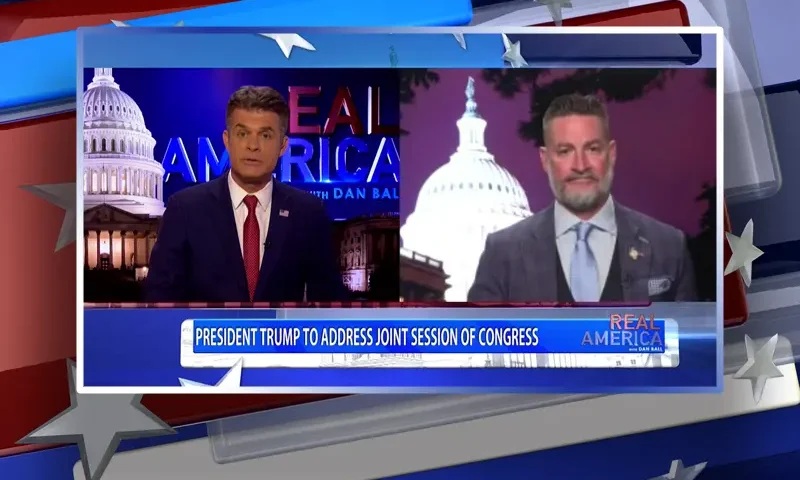 Video still from Real America on One America News Network showing a split screen of the host on the left side, and on the right side is the guest, Rep. Greg Steube.