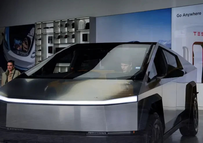 A person sits inside a Tesla Cybertruck at a Tesla showroom in New York City, U.S., January 2, 2025. REUTERS/Adam Gray/File Photo
