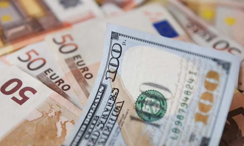 A $100-dollar bill is seen on top of Euro bills in Bogota, on July 12, 2022. The euro struck parity with the dollar for the first time in nearly 20 years on Tuesday as a cut in Russian gas supplies to Europe heightened fears of a recession in the eurozone. (Photo by DANIEL MUNOZ / AFP) (Photo by DANIEL MUNOZ/AFP via Getty Images)