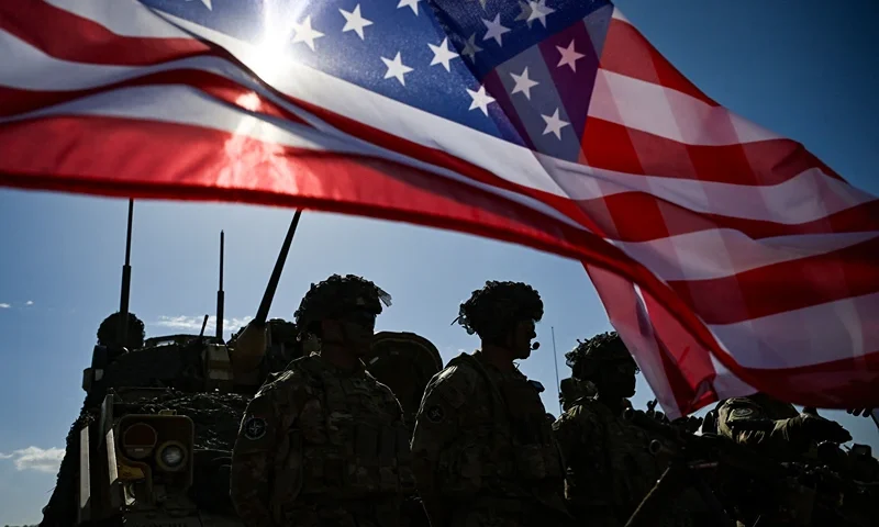 US Army soldiers stand in formation next to a US flag and a US Army armoured vehicle as they take part in the NATO "Noble Blueprint 23" joint military exercise at the Novo Selo military ground, northwestern Bulgaria, on September 26, 2023. More than two hundred soldiers from Bulgaria, Italy, USA, Greece, North Macedonia, Albania, Montenegro and Turkey are taking part in the exercise to demonstrate operational capabilities during the NATO "Noble Blueprint 23" joint exercise. (Photo by Nikolay DOYCHINOV / AFP) (Photo by NIKOLAY DOYCHINOV/AFP via Getty Images)