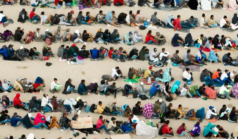 EL PASO, TEXAS - SEPTEMBER 21: In an aerial view, migrants are seen grouped together while waiting to be processed on the Ciudad Juarez side of the border on September 21, 2023 in El Paso, Texas. A recent surge of migrant crossings have occurred along the Southwestern region of the United States border. (Photo by Brandon Bell/Getty Images)
