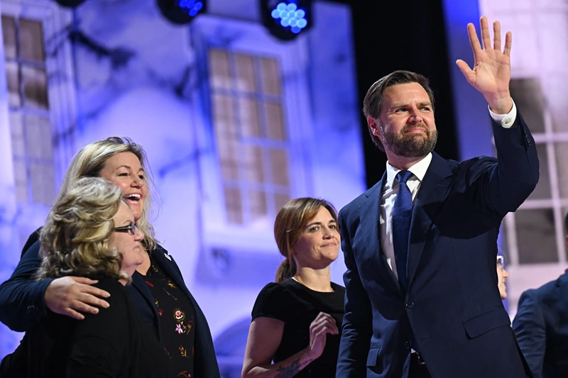 US Senator from Ohio and 2024 Republican vice presidential candidate J.D. Vance waves as his mother Bev Vance (L) smiles during the third day of the 2024 Republican National Convention at the Fiserv Forum in Milwaukee, Wisconsin, on July 17, 2024. Days after he survived an assassination attempt Donald Trump won formal nomination as the Republican presidential candidate and picked Ohio US Senator J.D. Vance for running mate. (Photo by Patrick T. Fallon / AFP) (Photo by PATRICK T. FALLON/AFP via Getty Images)