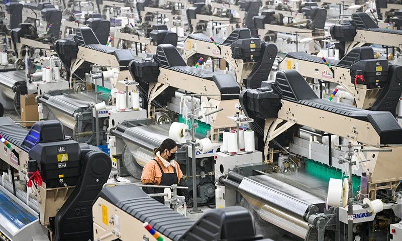 A woman works at a texile factory in Siyang County of Suqian municipality in east China's Jiangsu province on December 24, 2024. China will raise its deficit in order to boost spending next year, its finance minister said on December 24 according to state media, as Beijing looks to prop up its struggling economy. (Photo by AFP) / China OUT (Photo by STR/AFP via Getty Images)