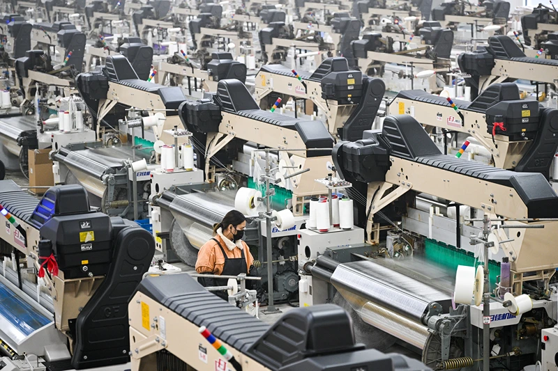 A woman works at a texile factory in Siyang County of Suqian municipality in east China's Jiangsu province on December 24, 2024. China will raise its deficit in order to boost spending next year, its finance minister said on December 24 according to state media, as Beijing looks to prop up its struggling economy. (Photo by AFP) / China OUT (Photo by STR/AFP via Getty Images)