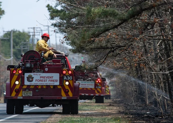 New Jersey Forest Fire Service fire crews work to extinguish the Jones Road Fire near Lacey Township in Ocean County, New Jersey, on April 23, 2025. Some 3,000 residents were evacuated in the US state of New Jersey after a wildfire exploded in size, scorching thousands of acres and threatening hundreds of structures, the state's fire service said on April 22. New Jersey had been under an official drought warning, the state's Department of Environmental Protection said in March. (Photo by Matthew Hatcher / AFP) (Photo by MATTHEW HATCHER/AFP via Getty Images)