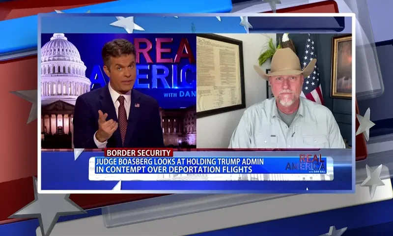 Video still from Real America on One America News Network showing a split screen of the host on the left side, and on the right side is the guest, Mark Lamb.