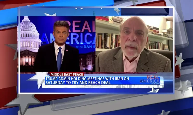 Video still from Real America on One America News Network showing a split screen of the host on the left side, and on the right side is the guest, Dov Hikind.