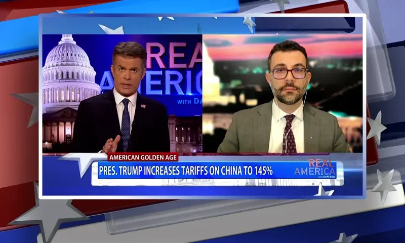 Video still from Real America on One America News Network showing a split screen of the host on the left side, and on the right side is the guest, Adam Savit.