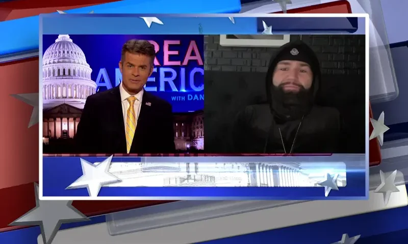Video still from Real America on One America News Network showing a split screen of the host on the left side, and on the right side is the guest, Jimmy Levy.