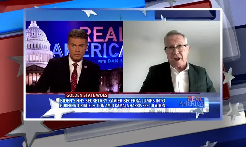 Video still from Real America on One America News Network showing a split screen of the host on the left side, and on the right side is the guest, Bill Wills.