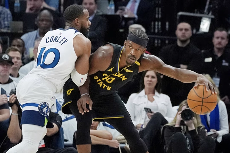 Minnesota Timberwolves guard Mike Conley (10) defends against Golden State Warriors forward Jimmy Butler (10) in the first quarter during game one of the second round for the 2025 NBA Playoffs at Target Center. Mandatory Credit: Bruce Kluckhohn-Imagn Images