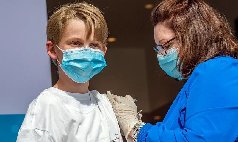 Charles Muro,age 13, is inoculated by a Nurse at Hartford Healthcare's mass vaccination center at the Connecticut Convention Center in Hartford, Connecticut on May 13, 2021. Six Children were vaccinated at the site and joined other children in the United States as kids ages 12-15 are now able to be vaccinated with the Pfizer-BioNTech Covid-19 vaccine, joining the growing population of the US that can be vaccinated against the Covid-19 virus. (Photo by Joseph Prezioso / AFP) (Photo by JOSEPH PREZIOSO/AFP via Getty Images)