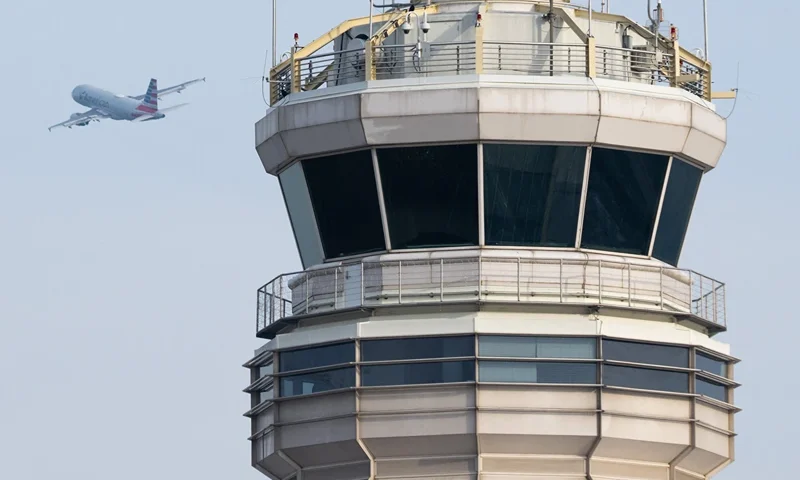 An American Airlines Airbus A319 airplane takes off past the air traffic control tower at Ronald Reagan Washington National Airport in Arlington, Virginia, January 11, 2023. The US Federal Aviation Authority said Wednesday that normal flight operations "are resuming gradually" across the country following an overnight systems outage that grounded departures. (Photo by SAUL LOEB / AFP) (Photo by SAUL LOEB/AFP via Getty Images)