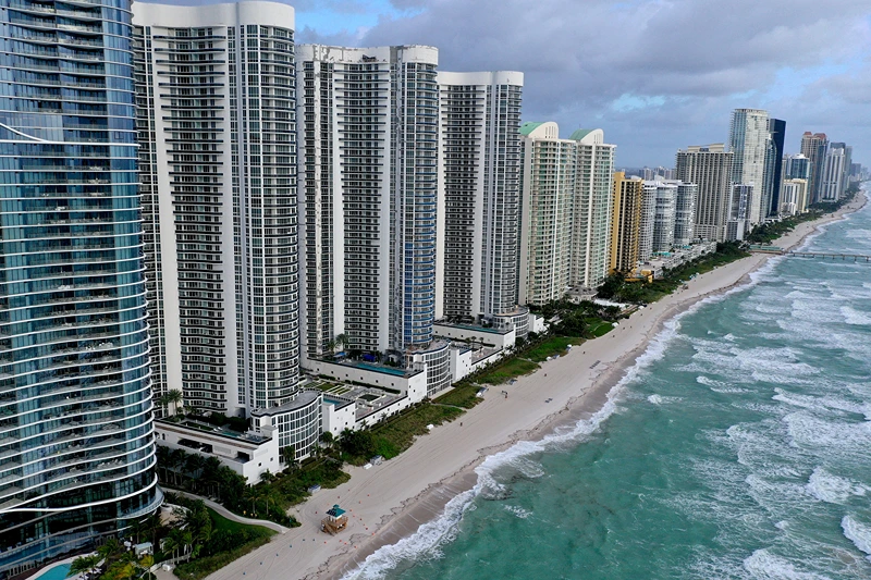 In an aerial view, a strip of beach separates the ocean from condo buildings on February 16, 2022 in Sunny Isles Beach, Florida. A new report released by climate scientists shows that sea levels along coastlines in the United States will rise about one foot by 2050, with larger increases on the East and Gulf coasts. (Photo by Joe Raedle/Getty Images)